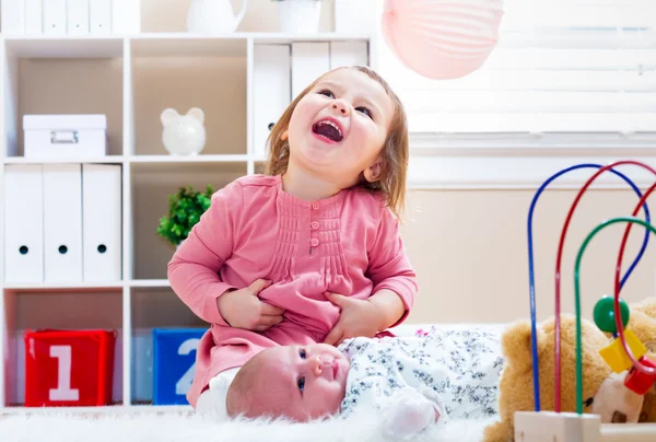 Glad tjej leker med hennes baby syskon — Stockfoto