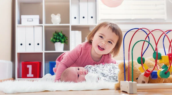 Glad tjej leker med hennes baby syskon — Stockfoto