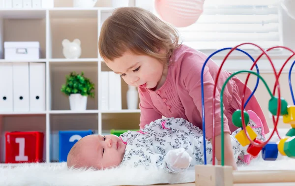 Mutlu kız onun bebek kardeşi ile oynamak — Stok fotoğraf