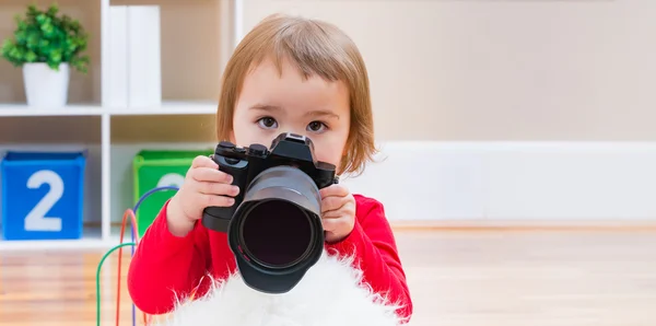 Κορίτσι μικρό παιδί παίζει με μια φωτογραφική μηχανή — Φωτογραφία Αρχείου