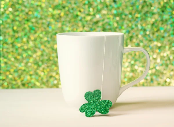 Green clover with white mug — Stock Photo, Image