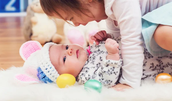 Dívka si hraje s její sestřičku na Velikonoce — Stock fotografie