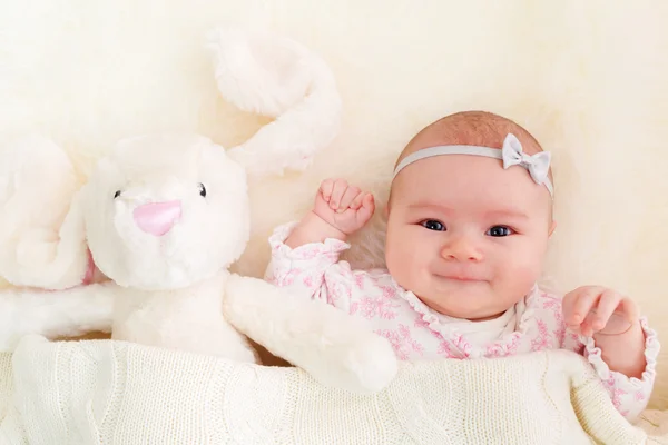 Bambino ragazza posa sulla sua coperta con il suo coniglietto ripieno — Foto Stock