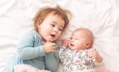 Yeni doğan kardeşi ile oynarken yürümeye başlayan çocuk kız