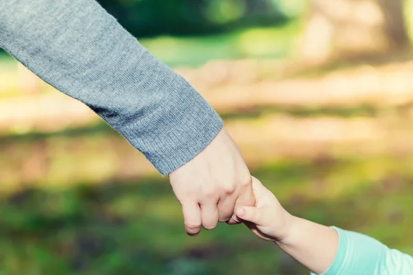 Peuter meisje hand in hand met haar ouder — Stockfoto