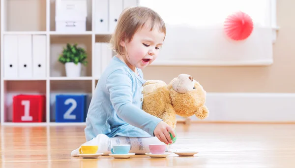 Petite fille prendre le thé avec son ours en peluche — Photo