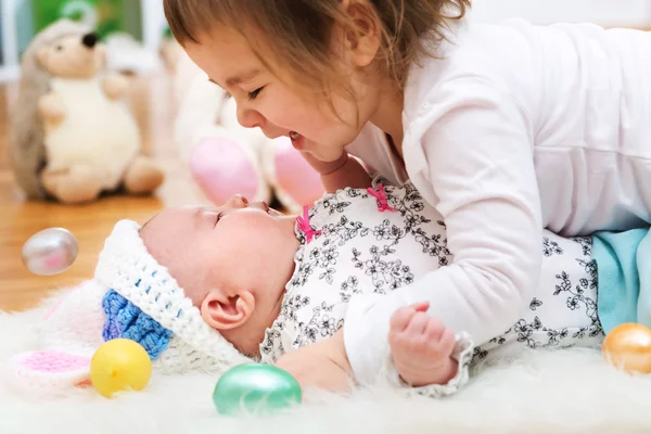 Chica jugando con su hermanita en Pascua —  Fotos de Stock