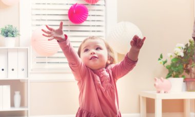 Oyuncakları ile oynarken mutlu yürümeye başlayan çocuk kız