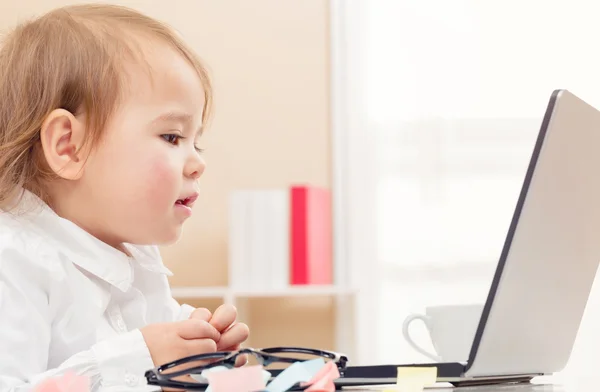 Kleuter meisje die op haar laptop werkt — Stockfoto