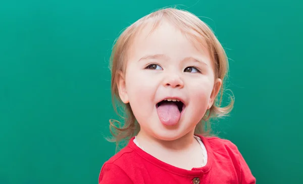 Feliz niña sacando la lengua. — Foto de Stock