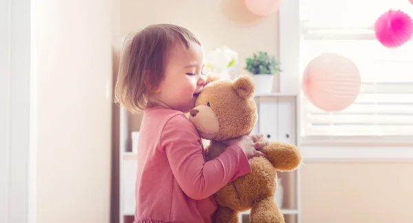 Šťastné batole dívka si hraje s její medvídek — Stock fotografie