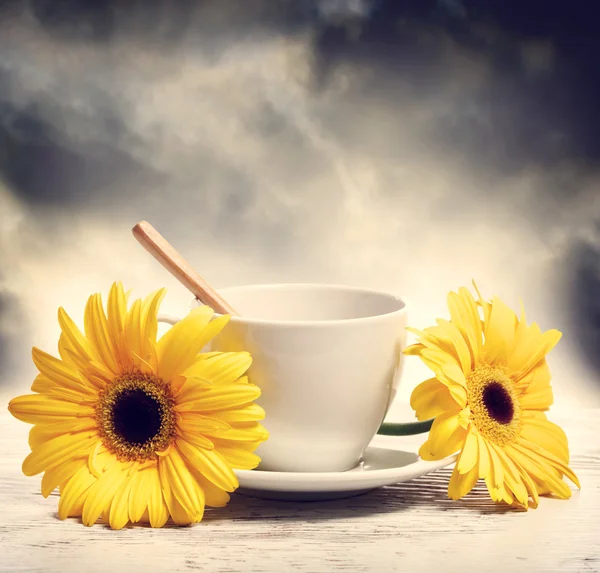 Coffee cup with yellow gerberas — Stock Photo, Image