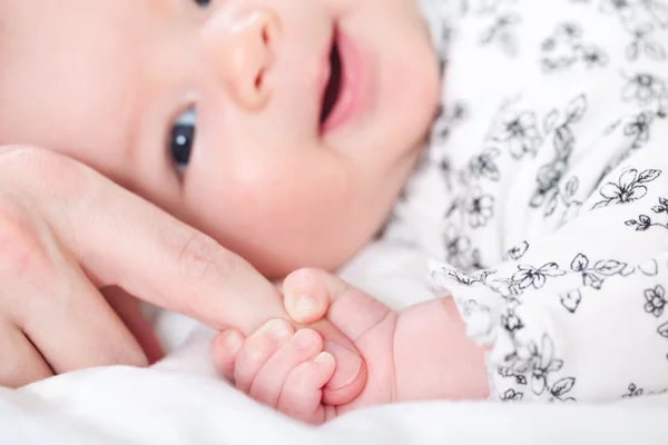 Babymeisje haar ouders vinger grijpen — Stockfoto