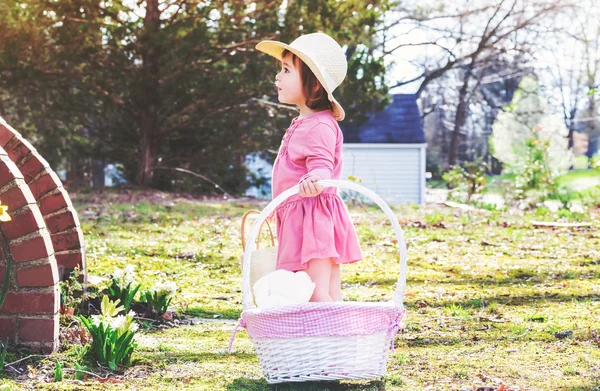 Chica jugando fuera con una cesta de Pascua —  Fotos de Stock