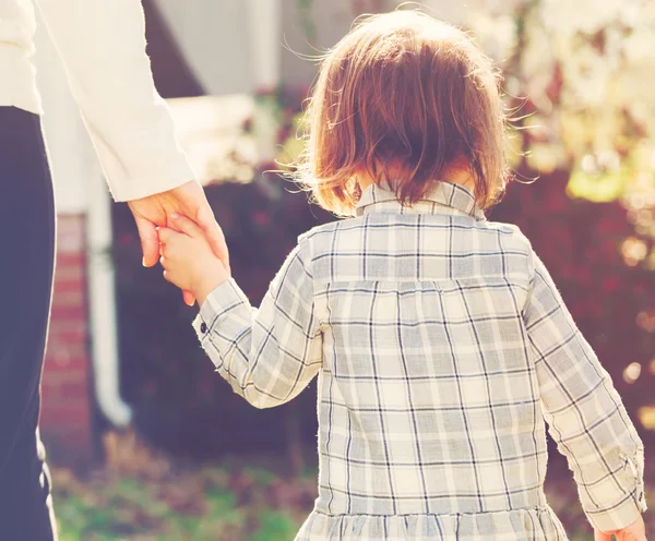 Toddler girl holding hands with her mother — Stock Photo, Image