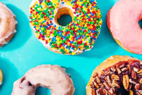 Geassorteerde donuts op pastel blauwe achtergrond — Stockfoto