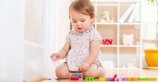 Κορίτσι μικρό παιδί που παίζει με τα παιχνίδια της — Φωτογραφία Αρχείου