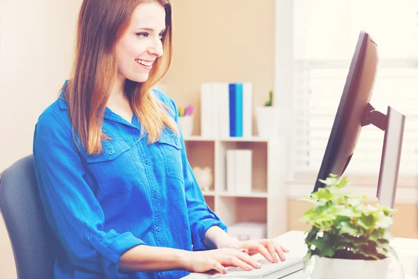 Щаслива жінка використовує свій комп'ютер — стокове фото