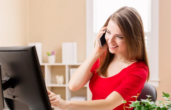 Mulher feliz falando ao telefone em seu escritório — Fotografia de Stock