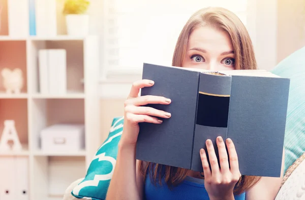 Mulher lendo um livro em seu sofá — Fotografia de Stock