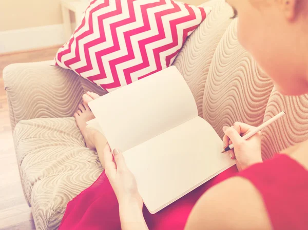 Mulher escrevendo em seu caderno em casa — Fotografia de Stock