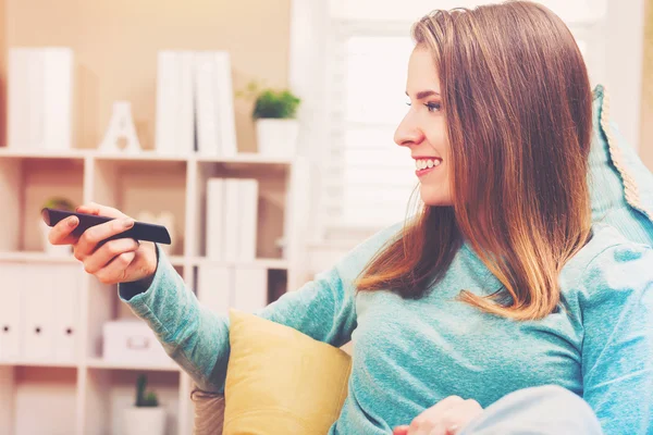 Mujer viendo la televisión en su casa — Foto de Stock