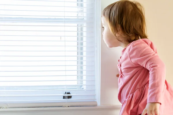 Ragazza del bambino che sbircia dalla finestra — Foto Stock