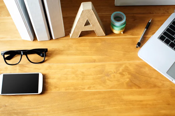 Arbeitsplatz mit Telefon, Brille, Laptop — Stockfoto