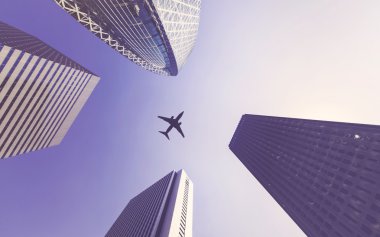Uzun şehir binaları arasında uçak uçuşları