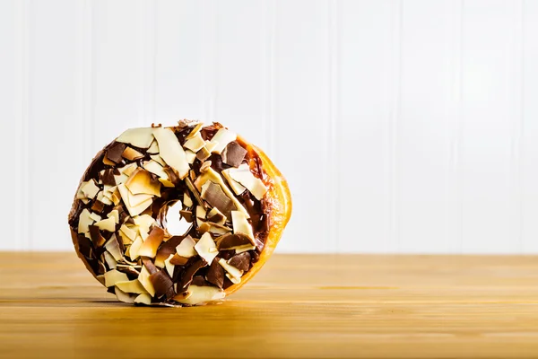 Donut de chocolate em uma mesa de madeira — Fotografia de Stock