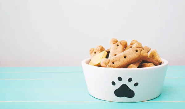 Hond behandelt in een kom op houten tafel — Stockfoto