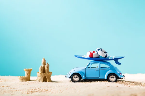 Миниатюрный синий автомобиль с доской для серфинга — стоковое фото