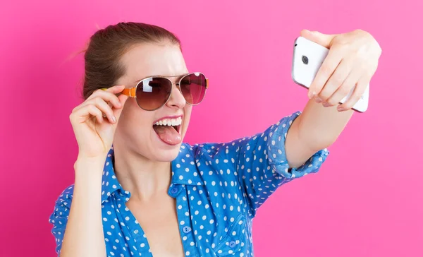 Ung kvinna som tar en selfie — Stockfoto