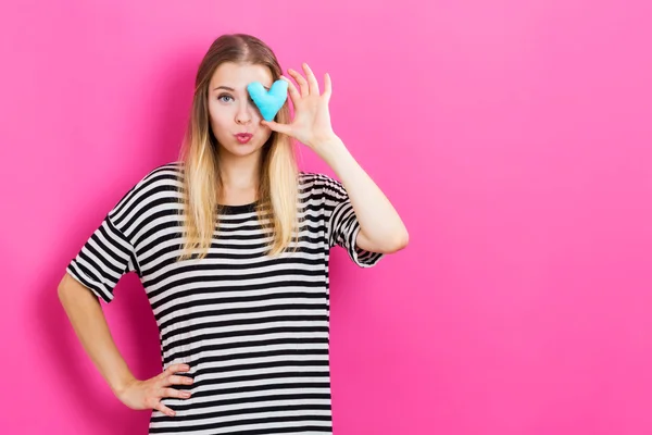 Mujer feliz sosteniendo un cojín del corazón — Foto de Stock