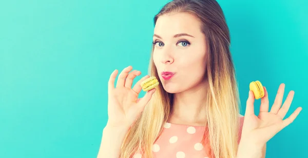 Feliz joven sosteniendo macarrones —  Fotos de Stock