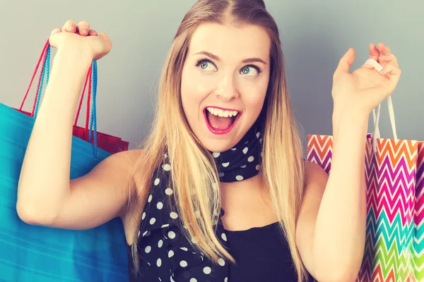 Mulher feliz segurando muitos sacos de compras — Fotografia de Stock