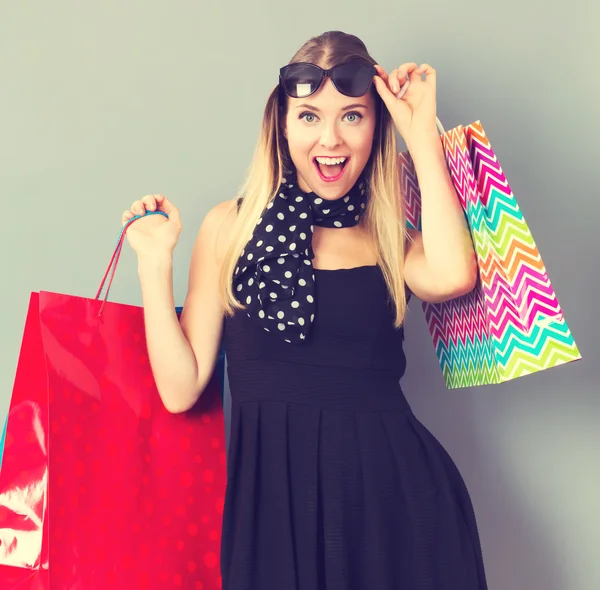 Gelukkige vrouw met veel shopping tassen — Stockfoto