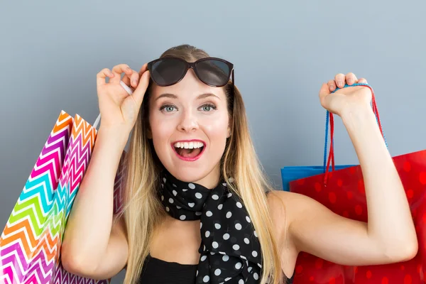 Glückliche Frau mit vielen Einkaufstüten — Stockfoto