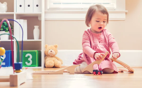 Ευχαρίστως toddler κορίτσι παίζει με τα παιχνίδια — Φωτογραφία Αρχείου