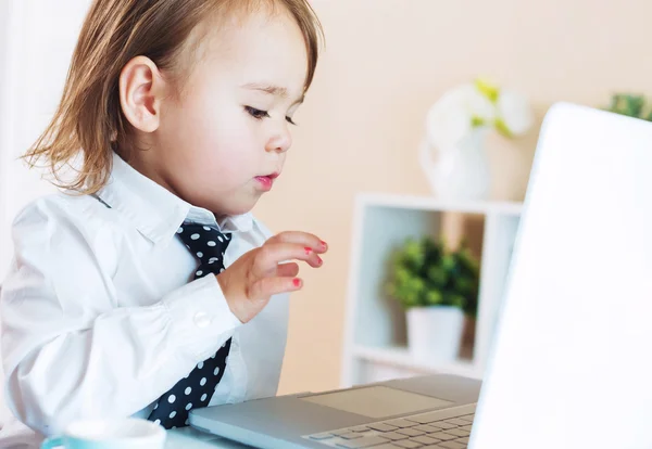 Ernstige peuter meisje met behulp van een laptop — Stockfoto