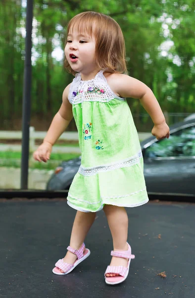 Gelukkig peuter meisje springen op een trampoline — Stockfoto
