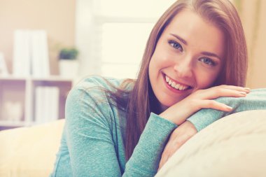 Oturma odasında gülümseyen genç kadın.