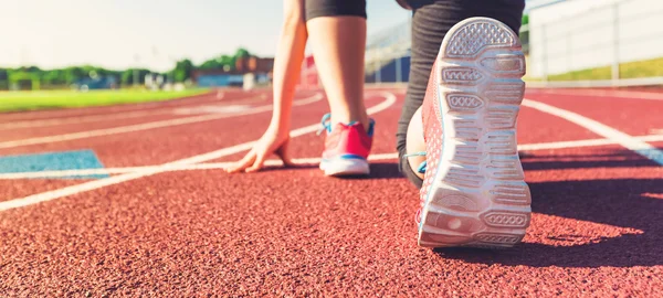 Female athlete on the starting line of a stadium track — Stock Photo, Image