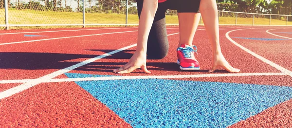 Atleta femenina en la línea de salida de una pista de estadio —  Fotos de Stock