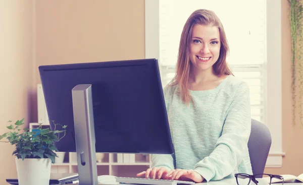 Mulher usando seu computador em seu escritório em casa — Fotografia de Stock