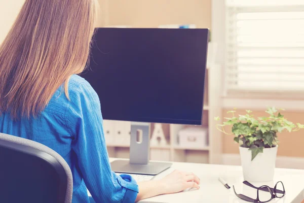 Mujer trabajando en su ordenador en su oficina en casa — Foto de Stock