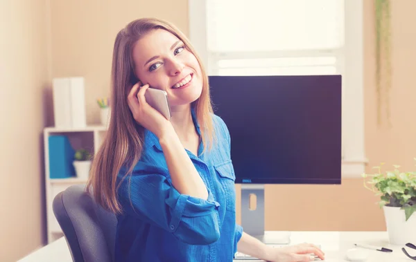 Donna che utilizza il suo smartphone nel suo ufficio a casa — Foto Stock