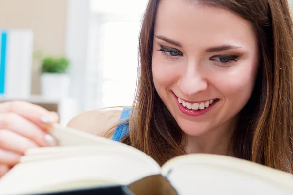 Glad ung kvinna läser en bok — Stockfoto