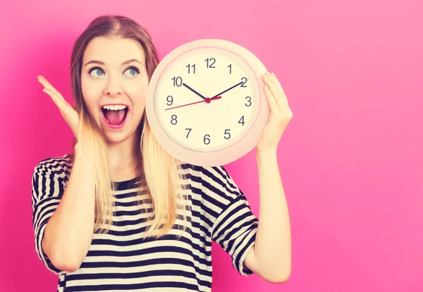 Mujer joven sosteniendo un reloj — Foto de Stock