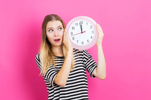 Mujer sosteniendo reloj mostrando casi 12 — Foto de Stock